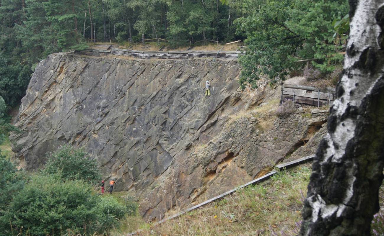 An der steilen Sandsteinwand trainiert ein Kletterer seine Künste. Weiter unten passen 2 seiner Kameraden auf, dass er den richtigen Weg findet. Foto: Friedhelm